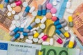 Different pills above euros bills. Royalty Free Stock Photo