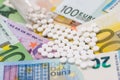 Different pills above euros bills. Royalty Free Stock Photo