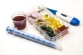 Different pills, medications in the box for drugs with medicine with a syringe and with thermometer on white background closeup.