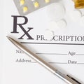 Different pills and silver color pen over medical prescription form - close up studio shot Royalty Free Stock Photo