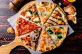 Different pizza slices on a wooden table mix