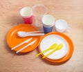 Different plastic and paper disposable cutlery on a wooden surface Royalty Free Stock Photo