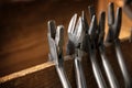 Different pliers from a goldsmith on a wooden tool holder on the