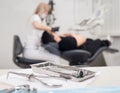 Different professional dental instruments, on the blurred background dentist is treating patient in dental clinic Royalty Free Stock Photo