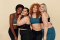 Different Race. Diversity Figure And Size Women Portrait. Hugging Multicultural Female In Sportswear Posing On Beige Background.