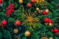 Red and yellow multicolored new year decorations on green christmas tree Royalty Free Stock Photo