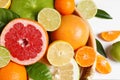 Different ripe citrus fruits with green leaves on white wooden table, flat lay Royalty Free Stock Photo