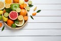 Different ripe citrus fruits with green leaves on white wooden table, flat lay. Space for text Royalty Free Stock Photo