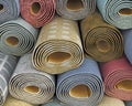 Different rolled carpets stacked one on another,