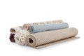 Different rolled carpets on white background.