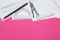 Different rulers, pencil and compass on pink background, flat lay. Space for text