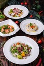 different salads in white plates on a wooden table Royalty Free Stock Photo