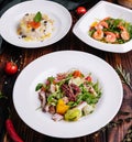 different salads in white plates on a wooden table Royalty Free Stock Photo