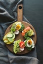 Different sandwiches with vegetables, eggs, avocado, tomato, rye bread on black chalkboard background. Top vew. Appetizer for part Royalty Free Stock Photo