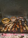 Different sausages are fried on a grate in the oven