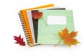 Different school exercise books with several autumn leaves Royalty Free Stock Photo