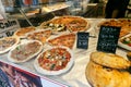 Different see pizzas on display in an italian store or bar