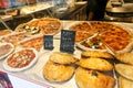 Different see pizzas on display in an italian store or bar