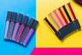 Different shades of lipsticks, pink, red, maroon, light and dark blue, yellow background, top view, close-up