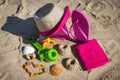 Different shapes made of sand, children toys for playing and accessories for relax. Straw hat, slippers and towel. Summer time on