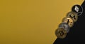 Different shining cryptocurrency coins. Bitcoin, litecoin, ethereum, monero and NEO on yellow and black background with