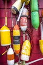 Various outboard used floats for mooring boats and schooners are decoratively hung on the painted wooden wall of the building