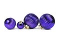 Different sized riffled purple Christmas glass ornament baubles in row on white Royalty Free Stock Photo