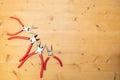 Different sizes of red pliers on a wooden background. Top view of repairing work tools on a wooden table Royalty Free Stock Photo