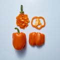 Different sliced yellow sweet peppers on a gray background, top view