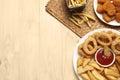 Different snacks and tasty ketchup on wooden table, flat lay. Space for text Royalty Free Stock Photo