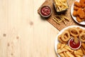 Different snacks and tasty ketchup on wooden table, flat lay. Space for text Royalty Free Stock Photo