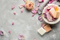 Different soap bars with rose petals on grey background