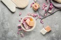 Different soap bars with rose petals on grey background