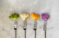 Different sort of cauliflower cabbage on grey concrete background with forks. Top view with copy space Royalty Free Stock Photo