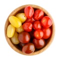 Different sorts of multi colored cherry tomatoes in wooden bowl isolated on white background. Top view Royalty Free Stock Photo