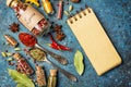 Different spices, dry kitchen herbs and seeds for tasty meals and mock-up of craft paper notebook Royalty Free Stock Photo