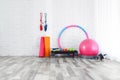 Different sports equipment near white brick wall in gym