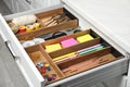 Different stationery in open desk drawer