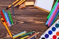 Different stationery - pencils, pen, note, erazer, paint on wooden background