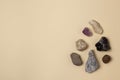 Different stones, precious and rocks on a beige background. Gemological concept. Study of minerals and bowels of the earth.