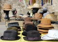 Different style men hats on a shelf of a street market. On background, manikin heads wearing straw hats Royalty Free Stock Photo