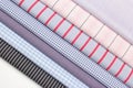 Different styles of folded cotton shirts displayed on a white surface Royalty Free Stock Photo