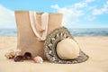 Stylish beach objects, coral and seashell on sand near sea Royalty Free Stock Photo