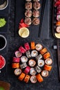 Different sushi rolls set  with fish and  shiitake mushrooms  served  at black dish with rise at black table. flat lay Royalty Free Stock Photo