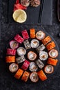 Different sushi rolls set  with fish and  shiitake mushrooms  served  at black dish with rise at black table. flat lay Royalty Free Stock Photo