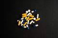 Different tablets, pills, medications drugs on black background