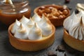 Different tartlets on dark grey table, closeup. Tasty dessert