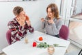 Portrait of young couple, concerned and pessimistic man and happy, excited, woman, who takes photos of food in cafe. Royalty Free Stock Photo