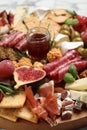 Different tasty appetizers on wooden board, closeup