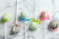 Different tasty cake pops on white marble background